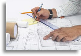 A person is drawing on top of some plans.